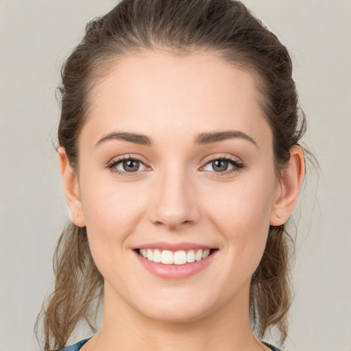 Joyful white young-adult female with medium  brown hair and green eyes