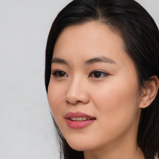 Joyful asian young-adult female with long  black hair and brown eyes