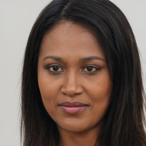 Joyful black young-adult female with long  brown hair and brown eyes