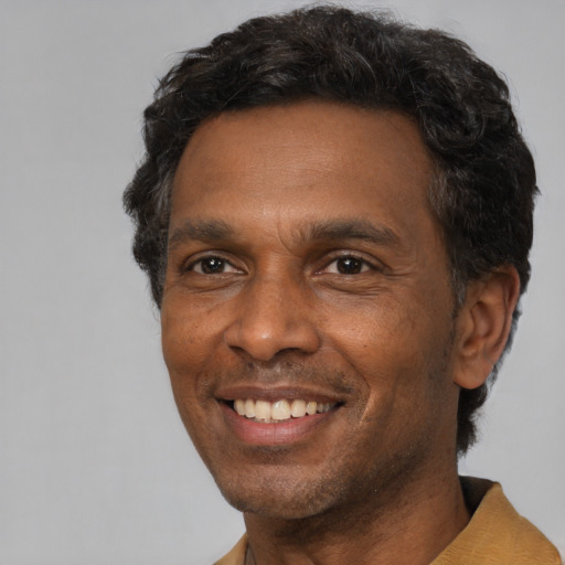 Joyful black adult male with short  black hair and brown eyes