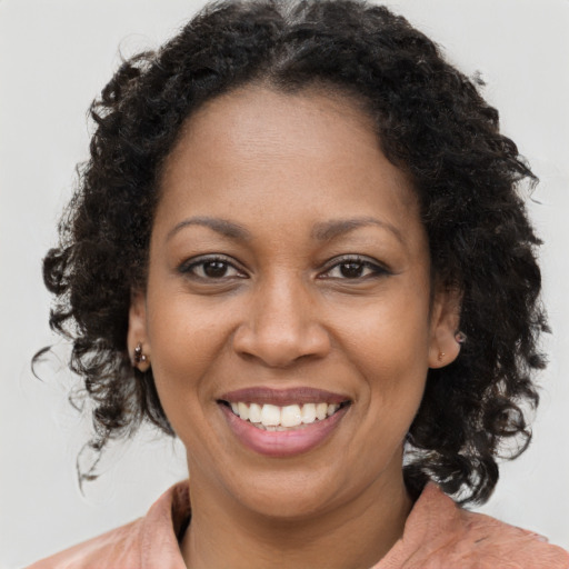 Joyful black adult female with medium  brown hair and brown eyes