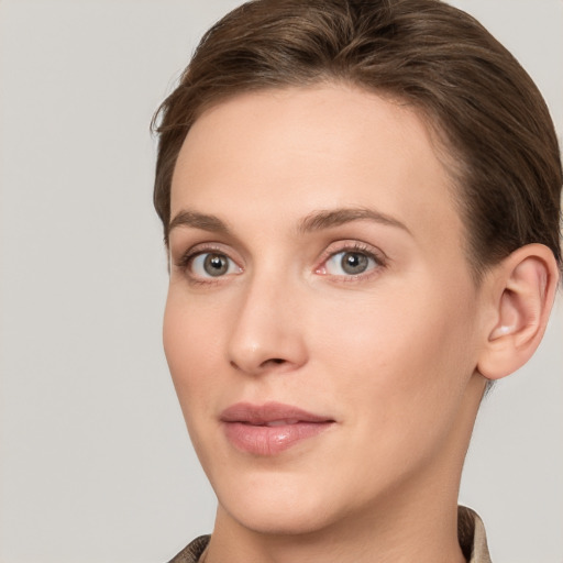 Joyful white young-adult female with short  brown hair and grey eyes