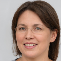 Joyful white adult female with medium  brown hair and grey eyes