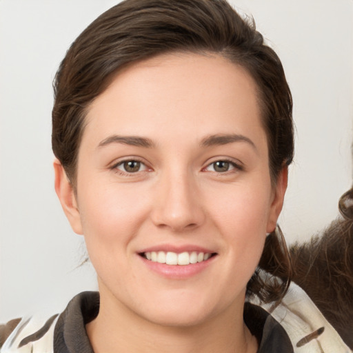 Joyful white young-adult female with medium  brown hair and grey eyes