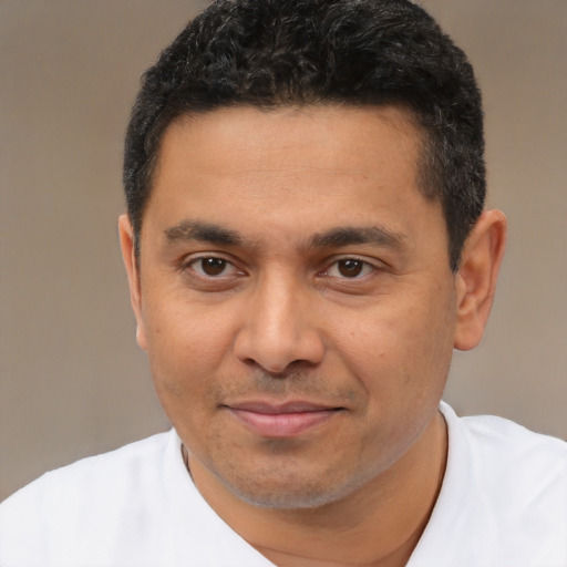 Joyful latino young-adult male with short  black hair and brown eyes