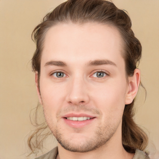 Joyful white young-adult male with medium  brown hair and grey eyes