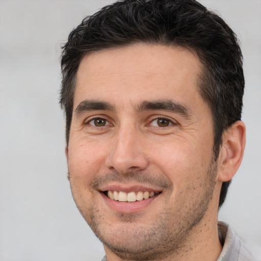 Joyful white adult male with short  brown hair and brown eyes