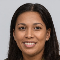 Joyful latino young-adult female with long  brown hair and brown eyes