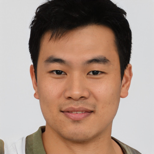 Joyful asian young-adult male with short  black hair and brown eyes
