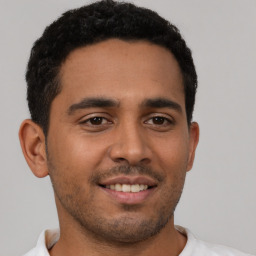 Joyful latino young-adult male with short  brown hair and brown eyes