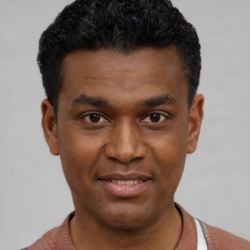 Joyful black young-adult male with short  black hair and brown eyes