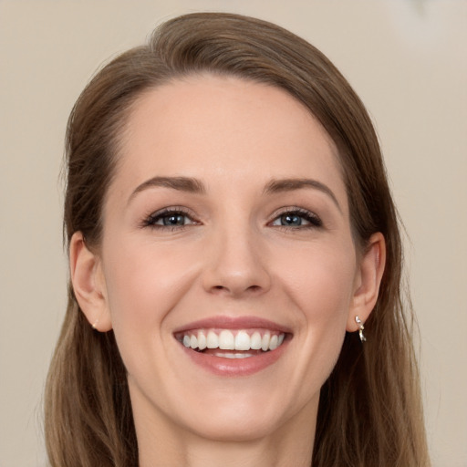 Joyful white young-adult female with long  brown hair and brown eyes