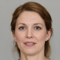 Joyful white adult female with medium  brown hair and grey eyes