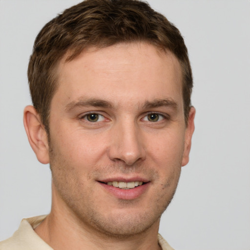 Joyful white young-adult male with short  brown hair and grey eyes