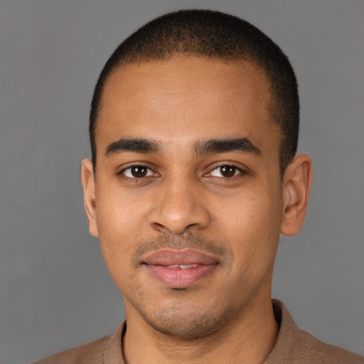 Joyful latino young-adult male with short  brown hair and brown eyes