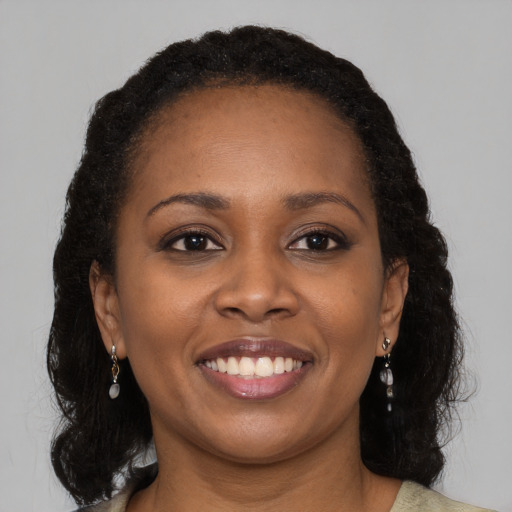 Joyful black young-adult female with long  brown hair and brown eyes