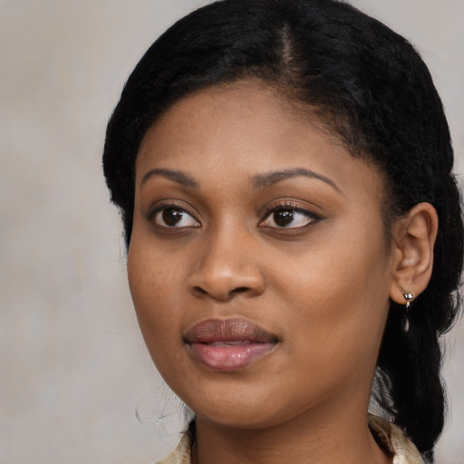 Joyful black young-adult female with long  black hair and brown eyes