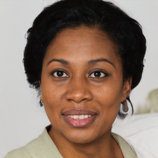 Joyful black adult female with medium  black hair and brown eyes