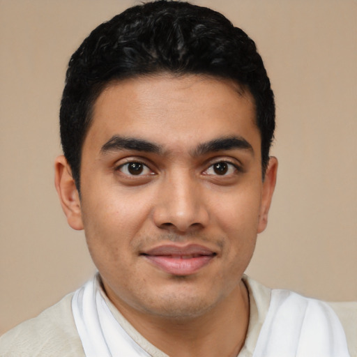 Joyful latino young-adult male with short  black hair and brown eyes