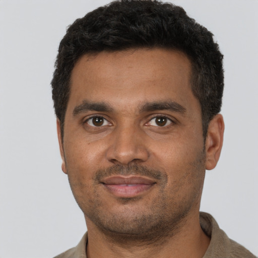 Joyful black young-adult male with short  brown hair and brown eyes