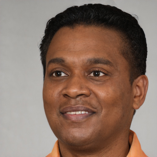 Joyful black adult male with short  brown hair and brown eyes
