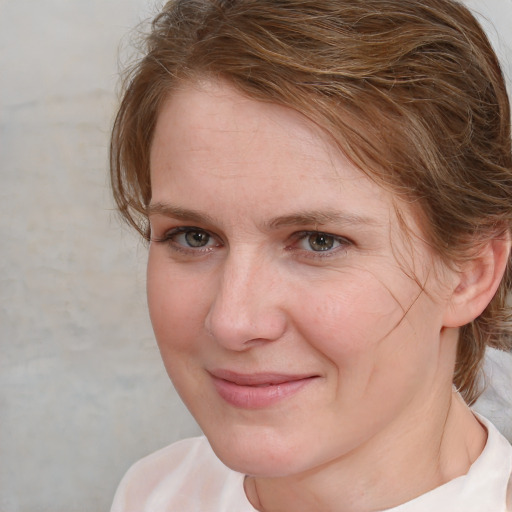 Joyful white adult female with medium  brown hair and blue eyes