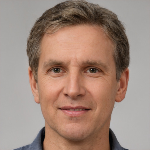 Joyful white adult male with short  brown hair and grey eyes