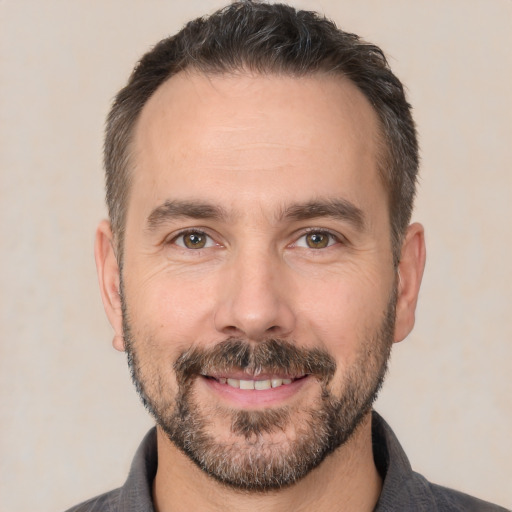 Joyful white adult male with short  brown hair and brown eyes