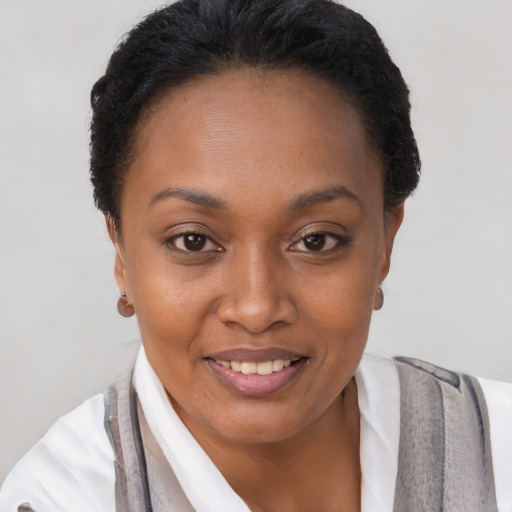 Joyful black young-adult female with short  brown hair and brown eyes