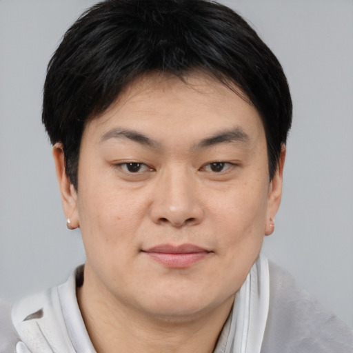 Joyful asian young-adult male with short  brown hair and brown eyes