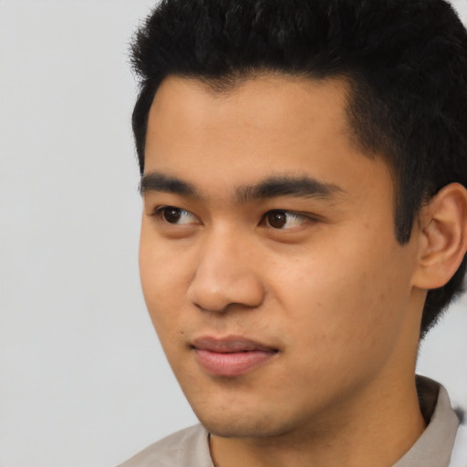 Joyful latino young-adult male with short  black hair and brown eyes