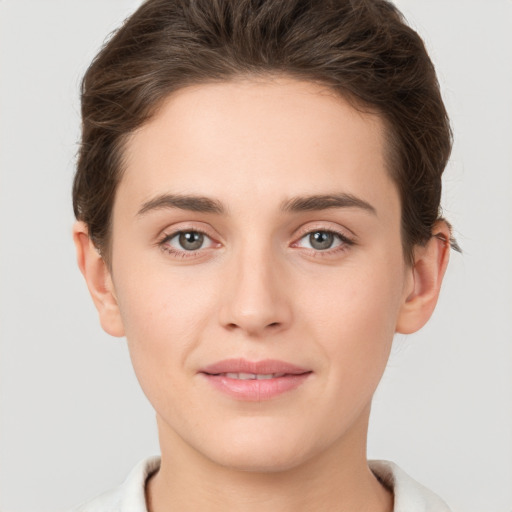 Joyful white young-adult female with short  brown hair and grey eyes