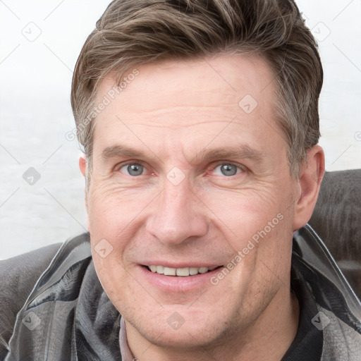 Joyful white adult male with short  brown hair and grey eyes