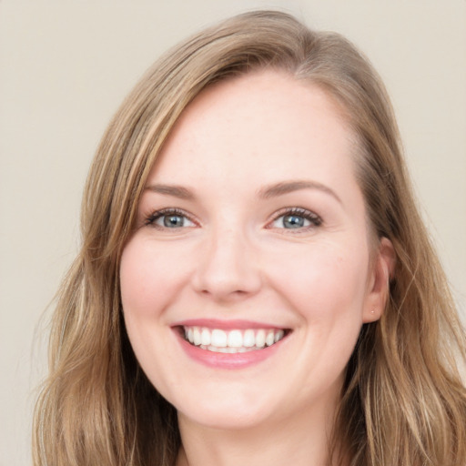 Joyful white young-adult female with long  brown hair and blue eyes