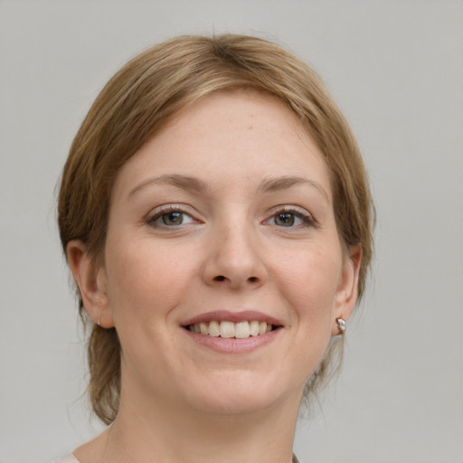 Joyful white young-adult female with medium  brown hair and grey eyes