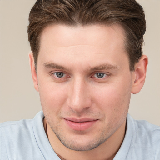 Joyful white young-adult male with short  brown hair and grey eyes