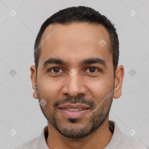 Joyful latino young-adult male with short  black hair and brown eyes