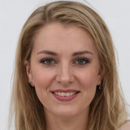 Joyful white young-adult female with long  brown hair and green eyes