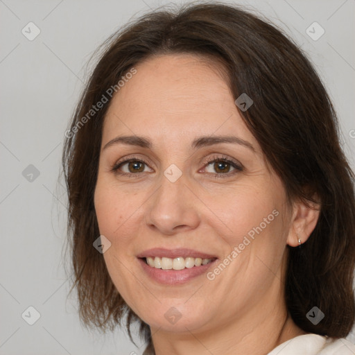 Joyful white adult female with medium  brown hair and brown eyes