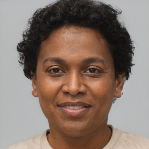 Joyful black adult female with short  brown hair and brown eyes