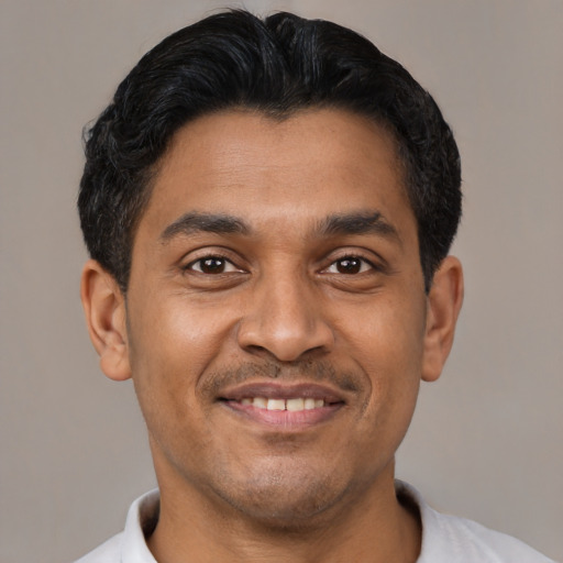 Joyful latino young-adult male with short  black hair and brown eyes