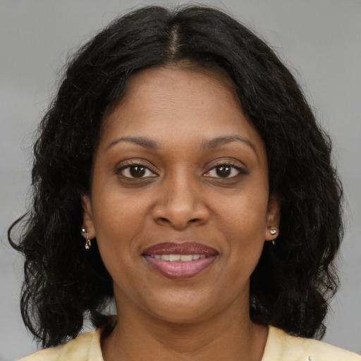 Joyful black young-adult female with medium  brown hair and brown eyes