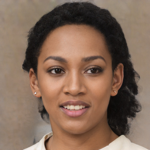 Joyful black young-adult female with long  black hair and brown eyes