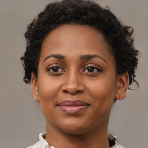 Joyful black adult female with short  brown hair and brown eyes