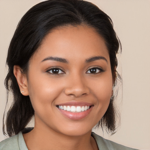 Joyful latino young-adult female with medium  brown hair and brown eyes