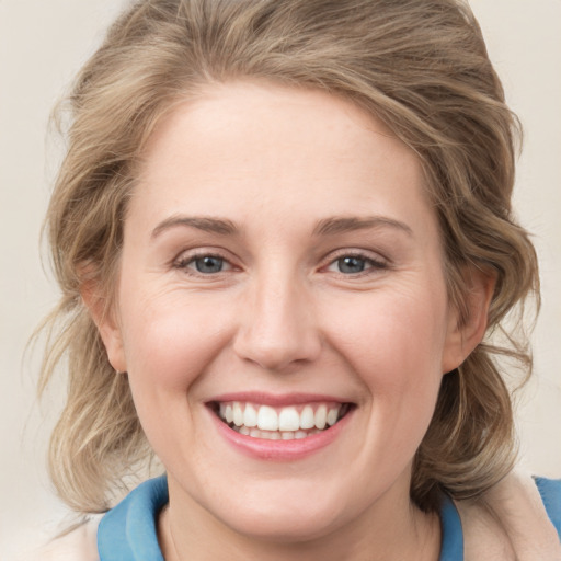 Joyful white young-adult female with medium  brown hair and blue eyes