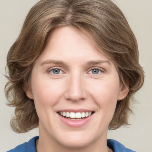 Joyful white young-adult female with medium  brown hair and blue eyes