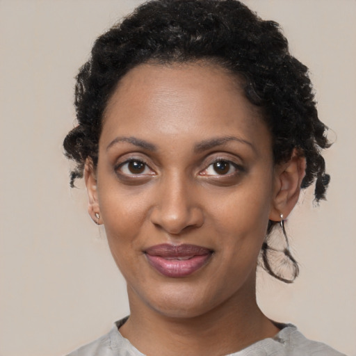 Joyful black young-adult female with short  black hair and brown eyes
