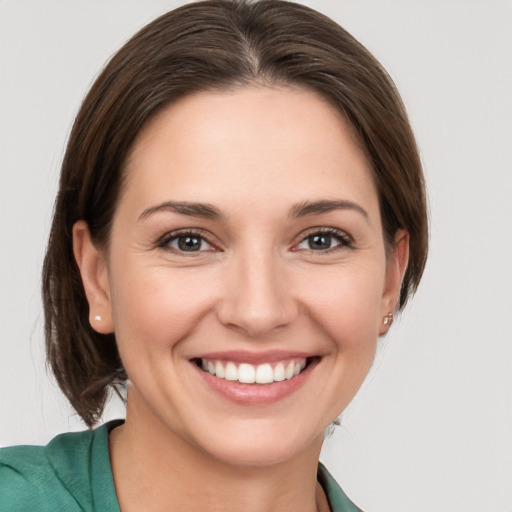 Joyful white young-adult female with medium  brown hair and grey eyes