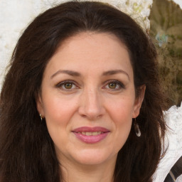 Joyful white adult female with long  brown hair and brown eyes